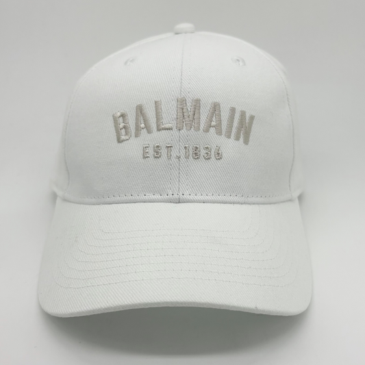 White cap with 'Balmain' branding on a light gray background